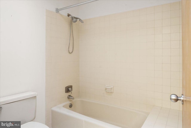 bathroom with toilet and tiled shower / bath