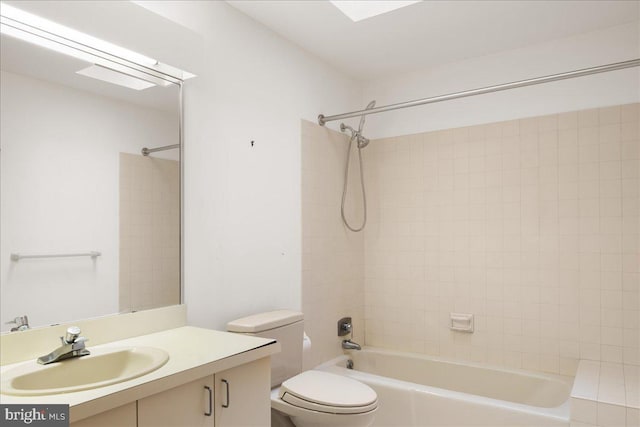 full bathroom featuring tiled shower / bath, vanity, and toilet