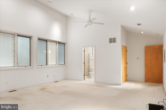 spare room featuring ceiling fan, light carpet, and high vaulted ceiling