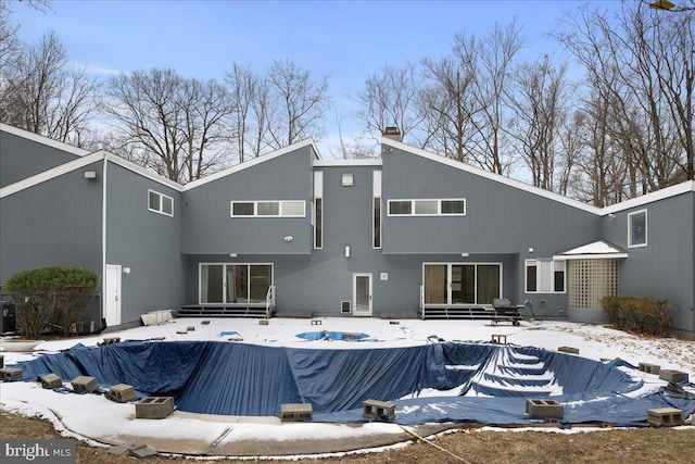 snow covered house with a covered pool