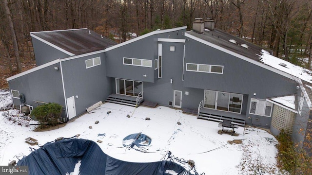 view of snow covered back of property