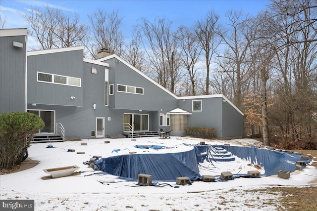 snow covered property featuring a covered pool