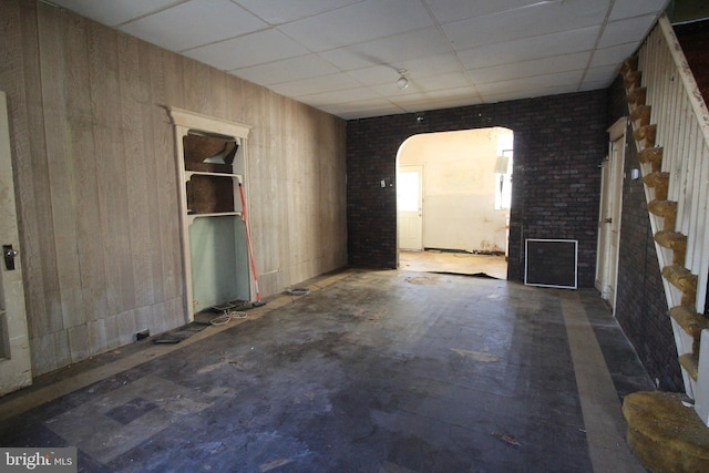 unfurnished living room featuring a drop ceiling