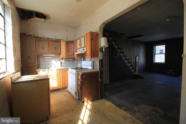 kitchen featuring white gas range and backsplash