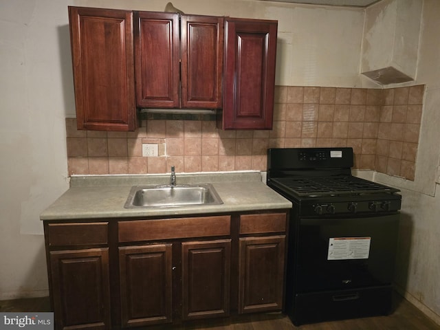 kitchen featuring decorative backsplash, sink, and black gas range oven