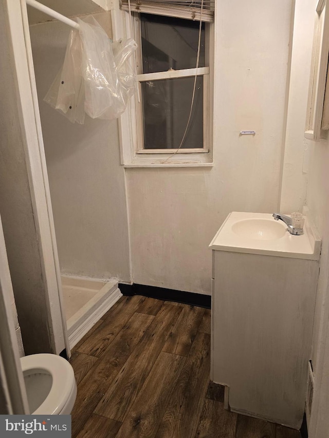 bathroom with toilet, walk in shower, wood-type flooring, and vanity