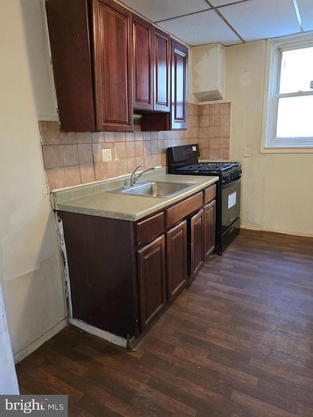 kitchen with black range with gas stovetop, a drop ceiling, tasteful backsplash, and sink