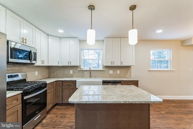 kitchen featuring light stone countertops, sink, white cabinetry, and appliances with stainless steel finishes