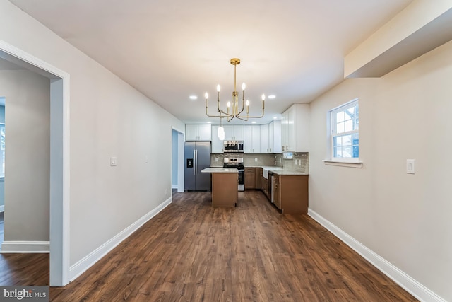 kitchen featuring white cabinetry, appliances with stainless steel finishes, tasteful backsplash, pendant lighting, and a center island