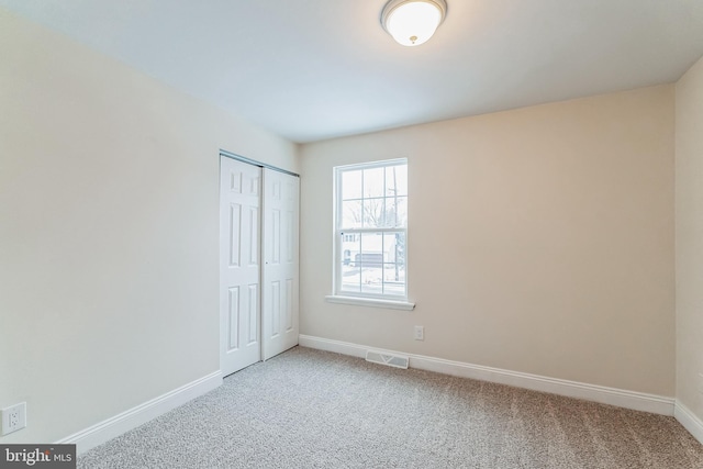 unfurnished bedroom with a closet and carpet flooring