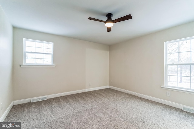 carpeted spare room with ceiling fan and a wealth of natural light