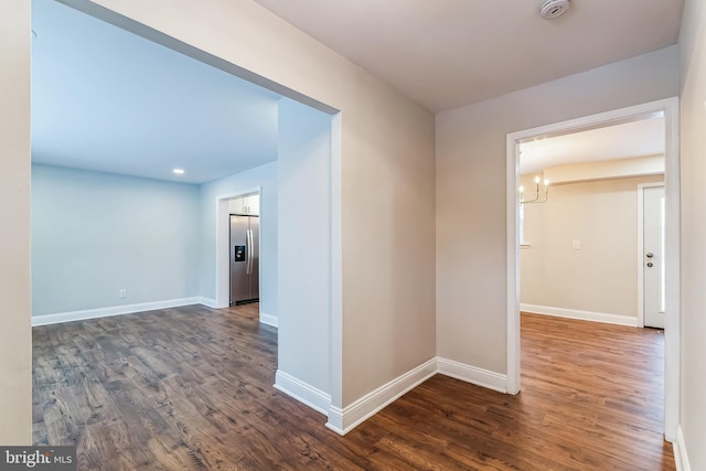 hallway with dark hardwood / wood-style flooring and an inviting chandelier