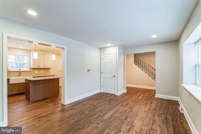 unfurnished living room with dark wood-type flooring and sink