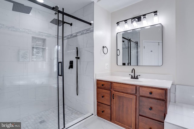 bathroom featuring marble finish floor, a stall shower, and vanity