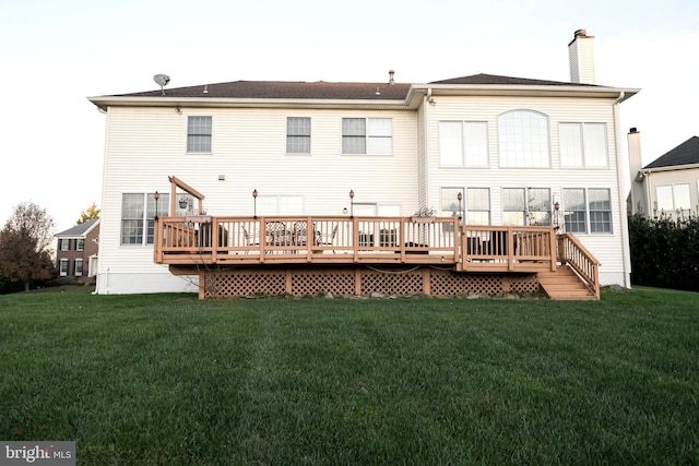 back of house with a deck, a chimney, and a yard