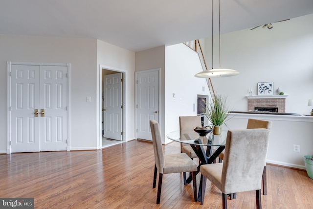 dining area featuring baseboards, wood finished floors, and a fireplace