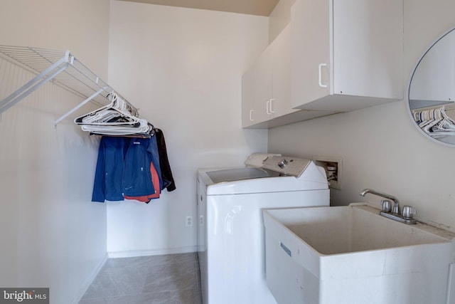 laundry area with cabinet space, washer and dryer, baseboards, and a sink