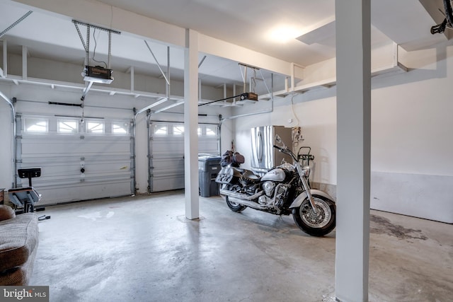 garage featuring a garage door opener and freestanding refrigerator