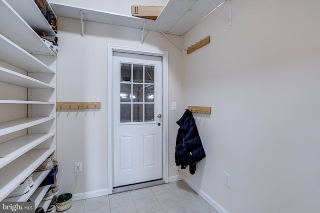 doorway to outside with light tile patterned flooring and baseboards