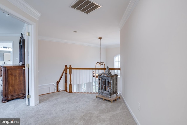 corridor with carpet, crown molding, an upstairs landing, and visible vents