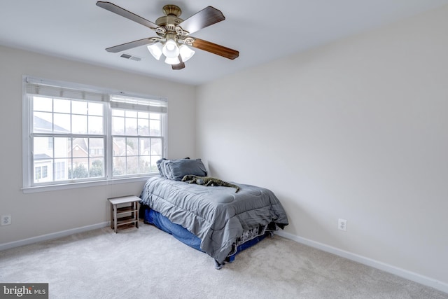 carpeted bedroom featuring visible vents, baseboards, and a ceiling fan