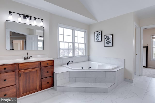 bathroom with vanity, vaulted ceiling, a bath, and marble finish floor