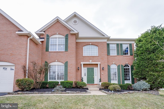 view of front of house with a garage, brick siding, and a front lawn