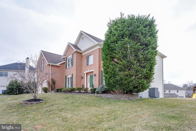 view of front of house featuring brick siding, central AC, and a front yard