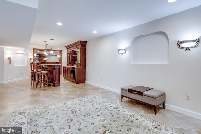 living room with bar area, recessed lighting, and baseboards