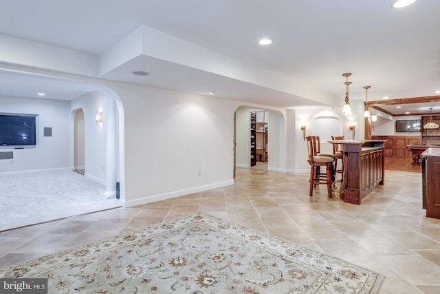 interior space featuring bar area, recessed lighting, arched walkways, and baseboards