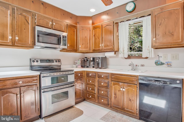 kitchen with light tile patterned floors, stainless steel appliances, and sink