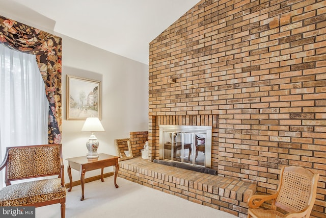 sitting room featuring lofted ceiling, a fireplace, and carpet floors