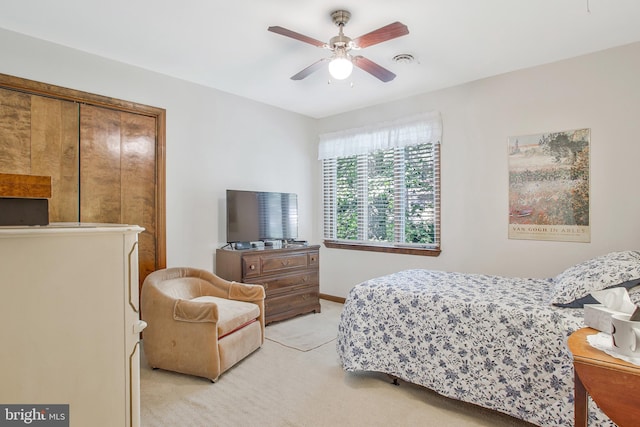 bedroom featuring ceiling fan, a closet, and light colored carpet