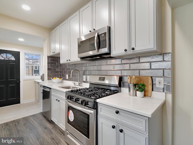 kitchen featuring stainless steel appliances, light hardwood / wood-style floors, white cabinetry, and sink