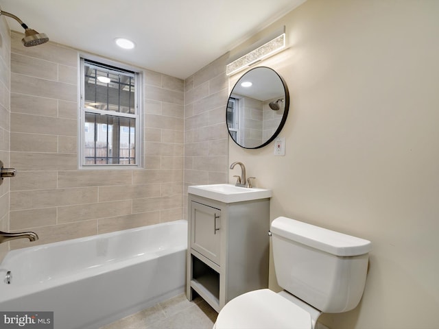 full bathroom featuring tile patterned floors, toilet, vanity, and tiled shower / bath combo