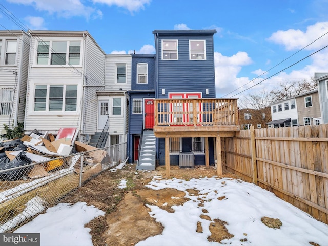 snow covered house featuring a wooden deck and central air condition unit