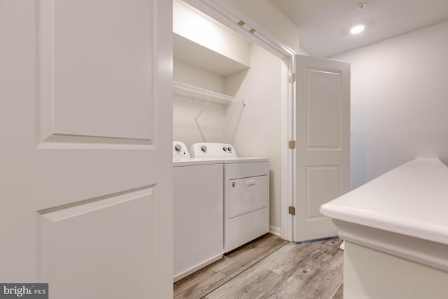 laundry area featuring washer and clothes dryer and light hardwood / wood-style flooring