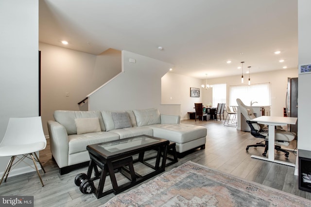 living room featuring an inviting chandelier and light hardwood / wood-style flooring