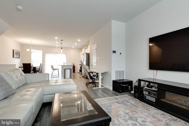 living room with wood-type flooring and a notable chandelier