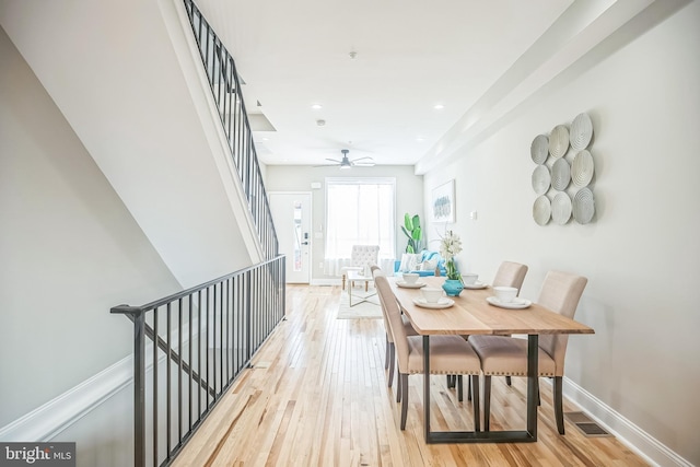 dining space with ceiling fan and light hardwood / wood-style flooring