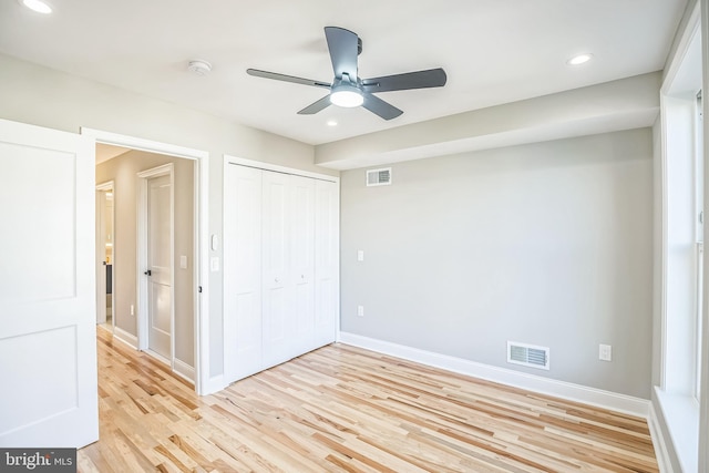 unfurnished bedroom featuring light hardwood / wood-style floors, a closet, and ceiling fan