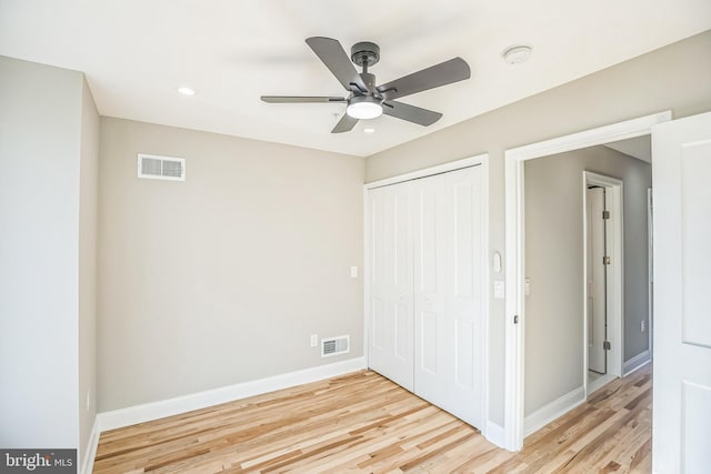 unfurnished bedroom with a closet, light hardwood / wood-style flooring, and ceiling fan