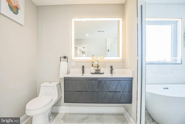 bathroom featuring a bathing tub, vanity, and toilet