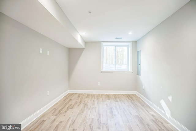 empty room with light hardwood / wood-style floors and electric panel