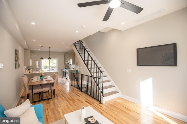 living room with ceiling fan and light hardwood / wood-style floors