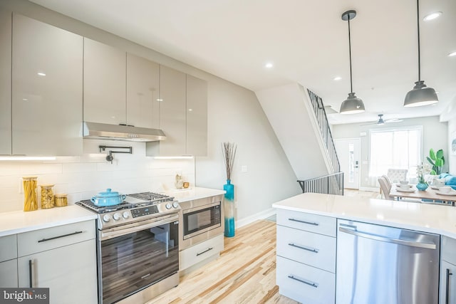 kitchen featuring decorative light fixtures, gray cabinets, light hardwood / wood-style floors, and appliances with stainless steel finishes