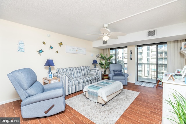 living room with a textured ceiling and ceiling fan