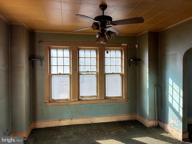 unfurnished room featuring a wealth of natural light, ceiling fan, and ornamental molding