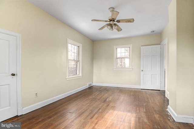 spare room with dark wood-type flooring and ceiling fan