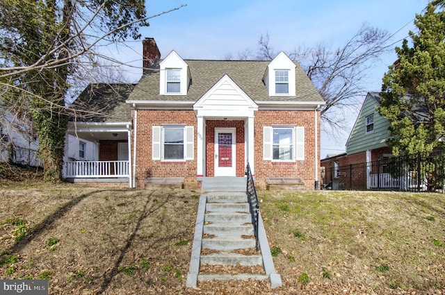 cape cod home with a front lawn